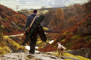 Man walking with hunting dog.
