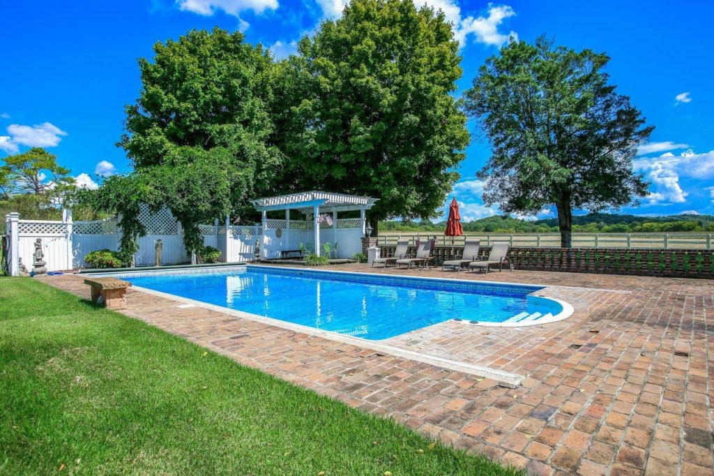 Gorgeous outdoor pool with cobblestone pathway.