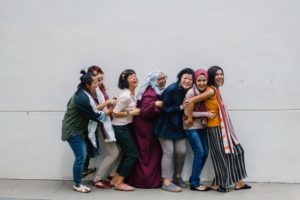 a group of 7 friends laughing and embracing