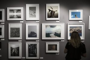 a woman looking at pictures in an art gallery