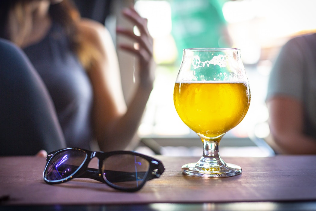 A glass of beer on a table.