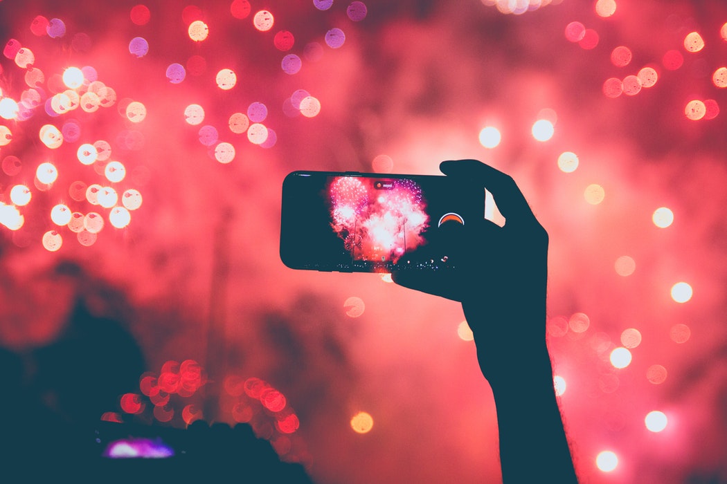 Recording fireworks on a cell phone.